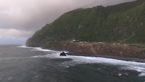 Vuele-Hacia-Una-Costa-Escarpada-Con-Un-Pequeño-Pueblo-En-La-Isla-De-Flores,-Azores---Disparo-De-Drones