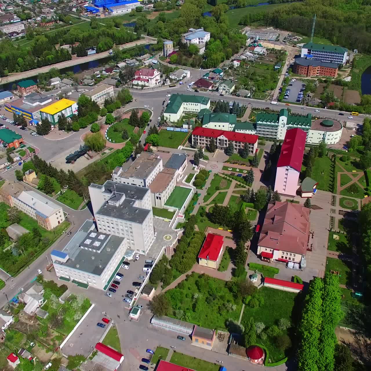 Flight over the residential districts with blocks of flats and cottages, roads and green areas. Aerial perspective on summer day