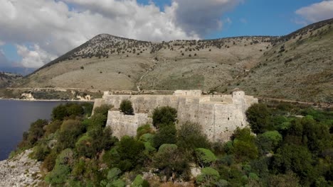 fortaleza de porto palermo en el borde de una isla rocosa, fuertes paredes de piedra con fondo de montaña