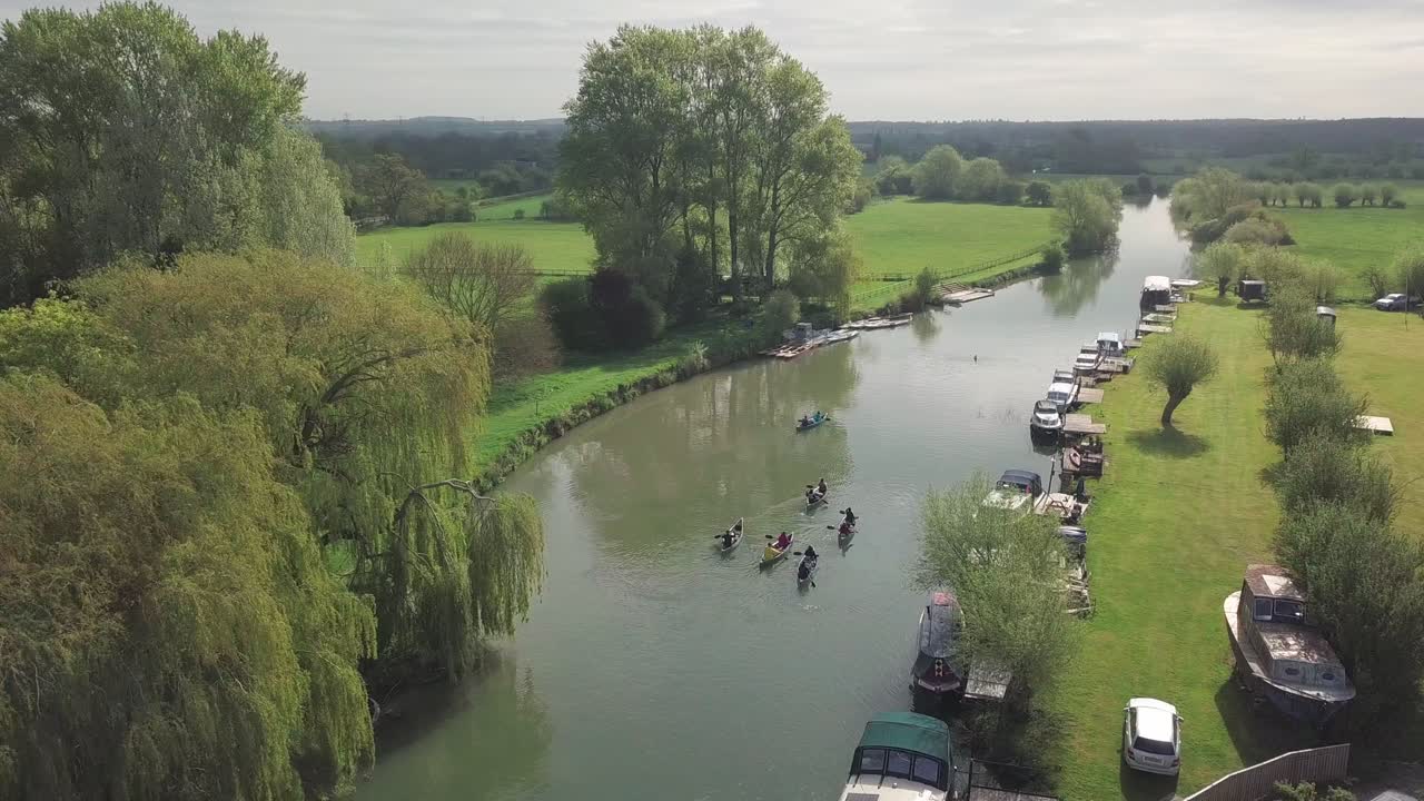 People Paddling Kayak On River Thames In Abingdon Town, Oxford City, UK During Summertime. - aerial drone shot