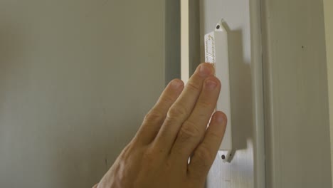 Jewish-Mezuzah-located-on-a-door---touched-by-a-hand