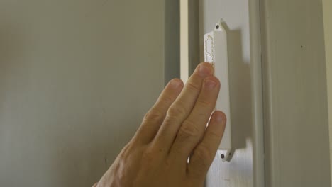 mezuzá judía ubicada en una puerta - tocada por una mano