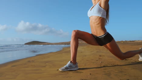 woman doing leg stretches. fitness girl stretching legs on beach training. slow motion steadicam