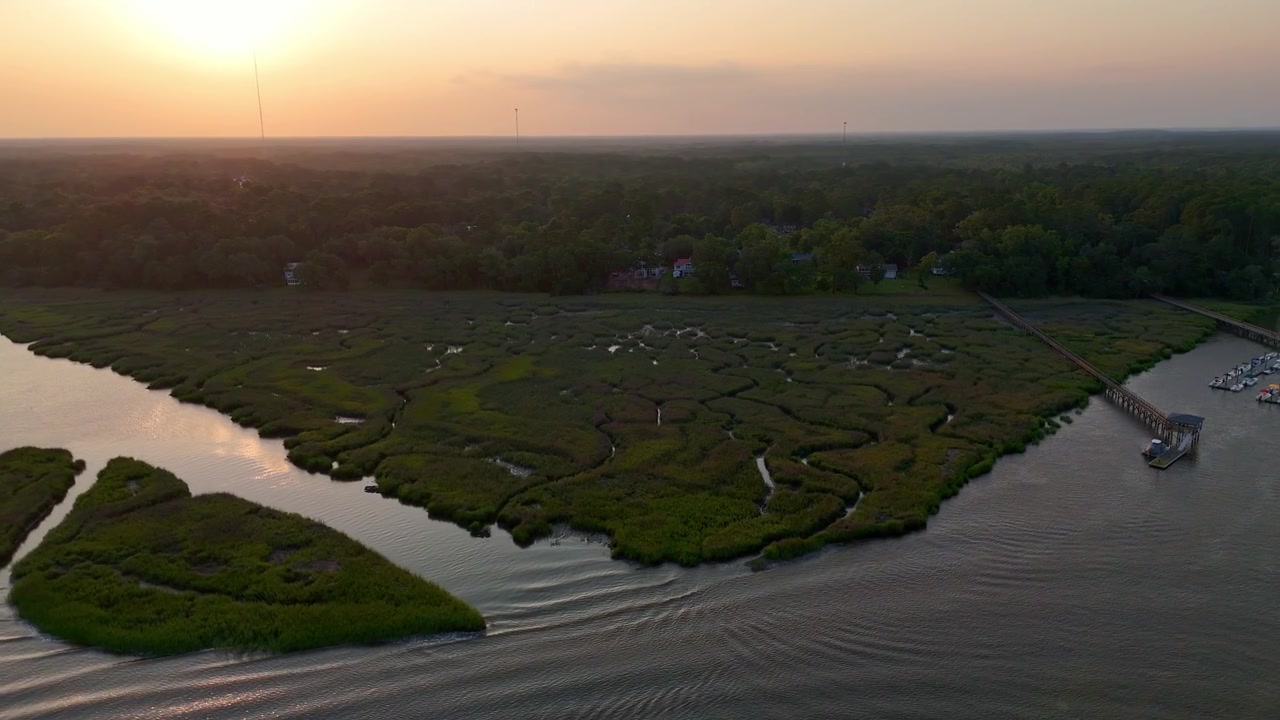 Filmato aereo con drone 4K che riprende il paesaggio intricato di paludi salmastre e pontili al tramonto a Shellman Bluff, Georgia, Stati Uniti d'America