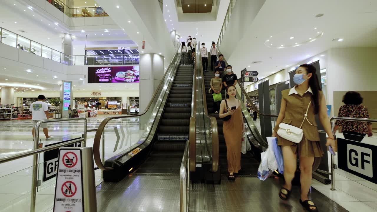 People riding escalators in a modern shopping mall