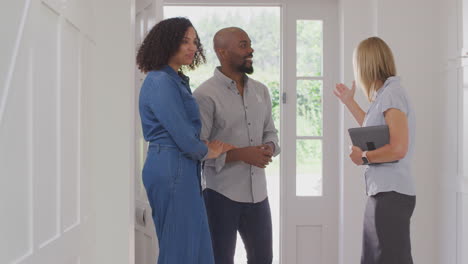 couple viewing potential new home with female realtor