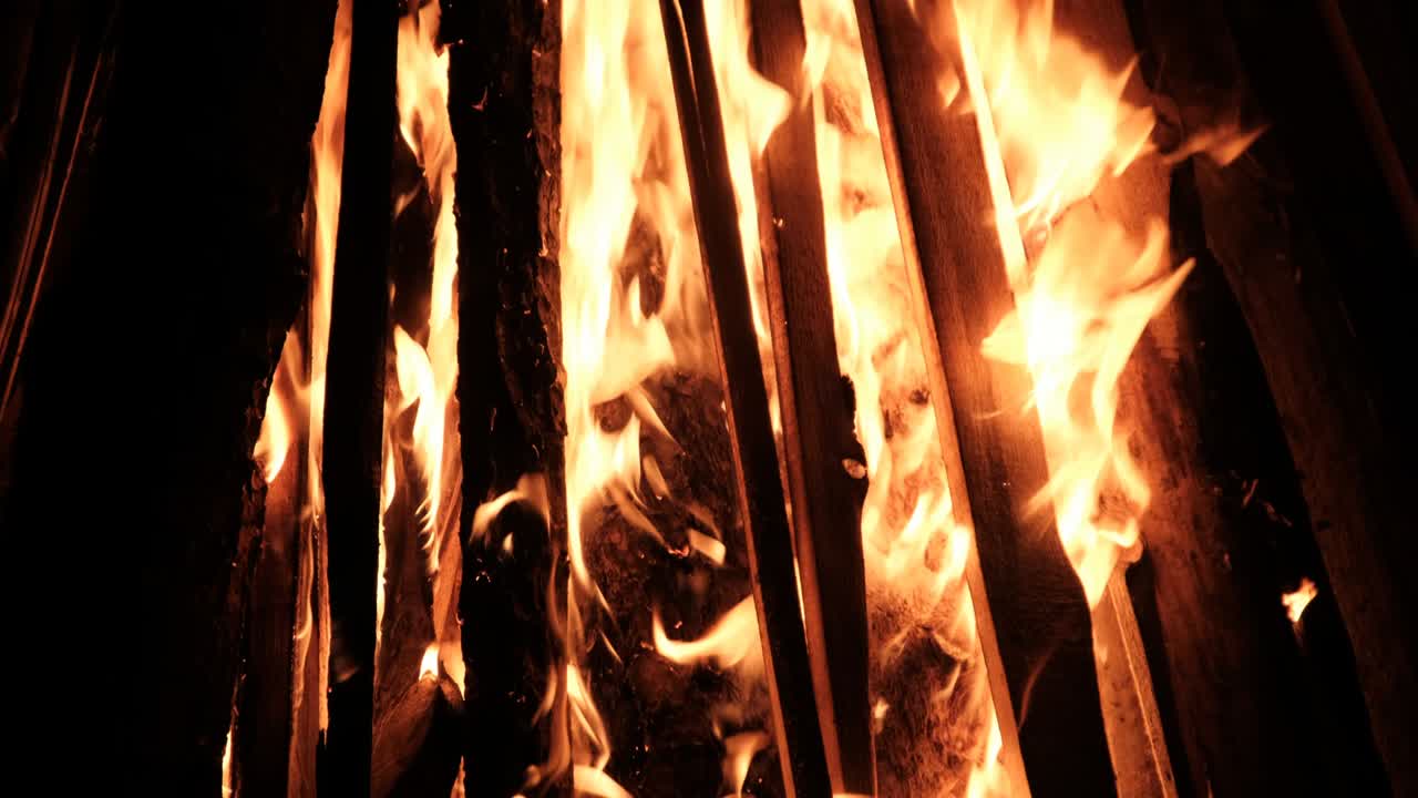 una gran hoguera arde por la noche en cámara lenta sobre un fondo negro en la naturaleza