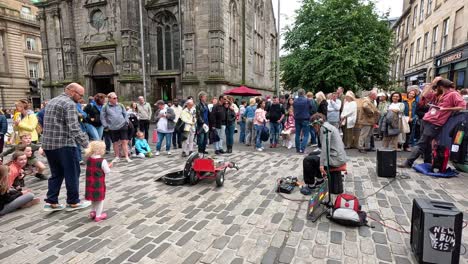 crowd gathers around street performer in edinburgh