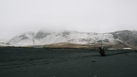 icelandic horse riding on a black sand beach