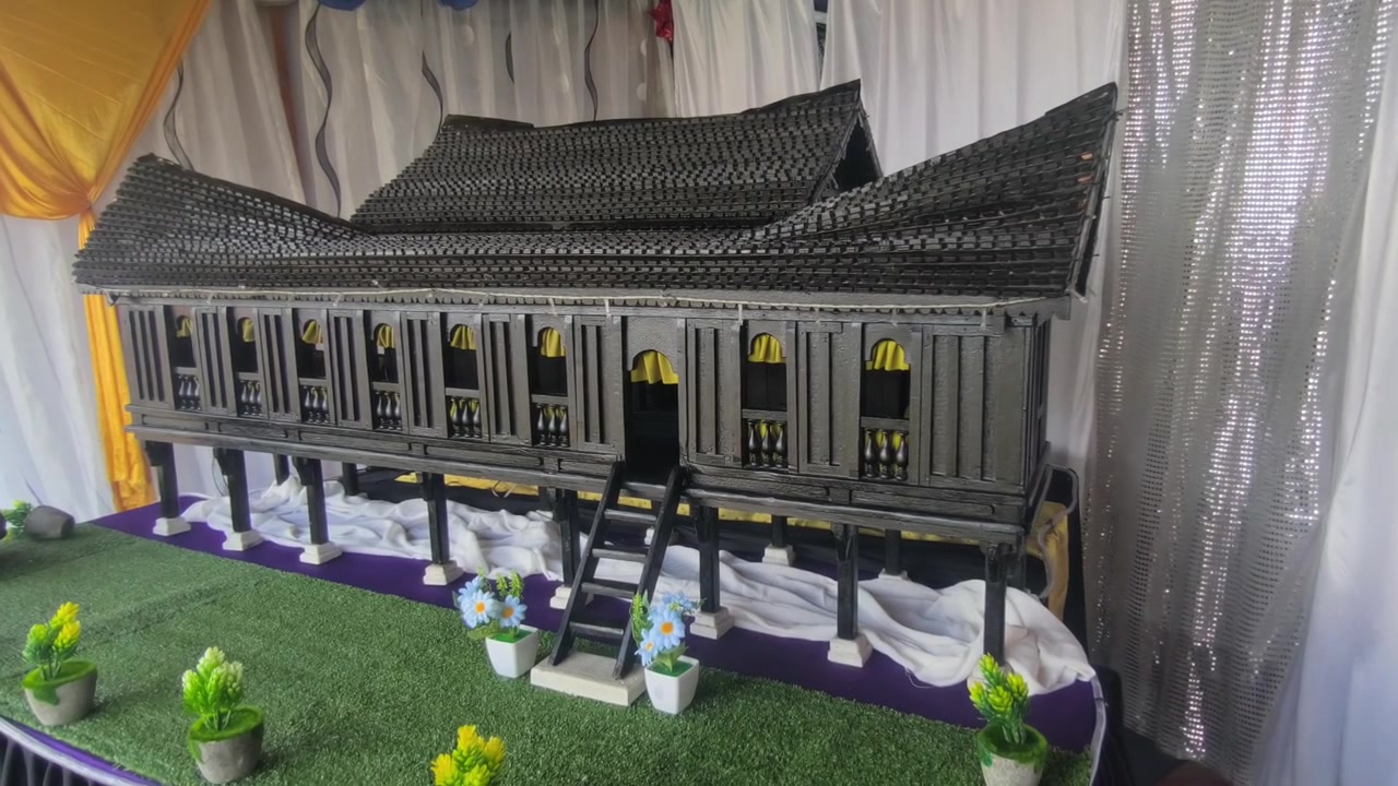 Model Miniatur Rumah Melayu Tradisional Negeri Sembilan Dipajang di Atas Meja. Pengunjung Mengagumi Kerajinan Arsitektur yang Detail Selama Pameran