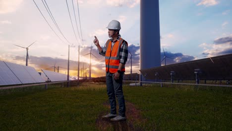 full body side view of angry asian male engineer with safety helmet shouting at someone while standing with solar panel and wind turbines