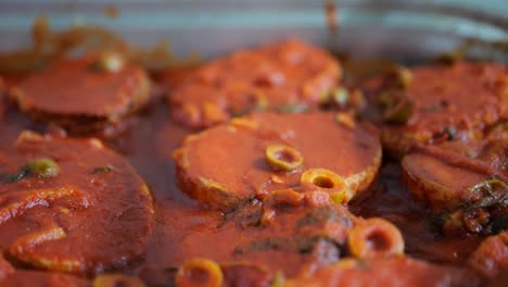 meat polpettes with olive sauce in large pan, close up