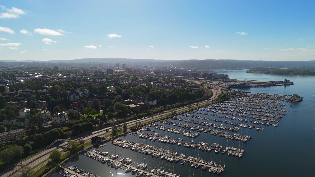 A bustling marina filled with boats against Oslo's urban skyline. Ideal for travel features or cityscape projects.