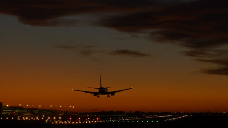 Silhouette-Eines-Flugzeugs,-Das-Bei-Sonnenuntergang-Am-Flughafen-Barcelona-Landet