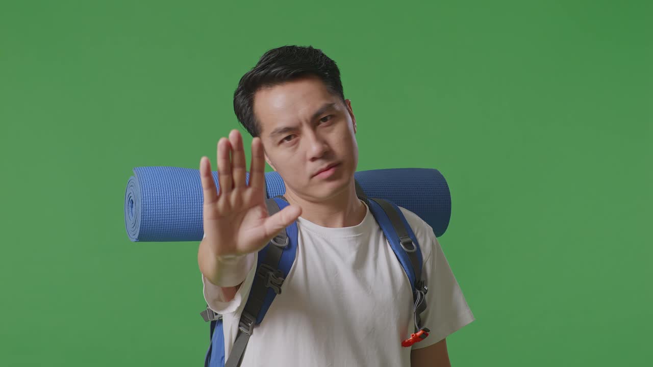 배 을 들고 있는 남자 가 멈추는 몸짓 을 하고 있다