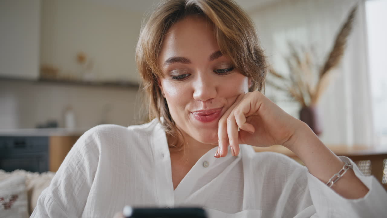 Primo piano di una signora sorridente che usa il cellulare per fare shopping online dal divano. Simpatica donna