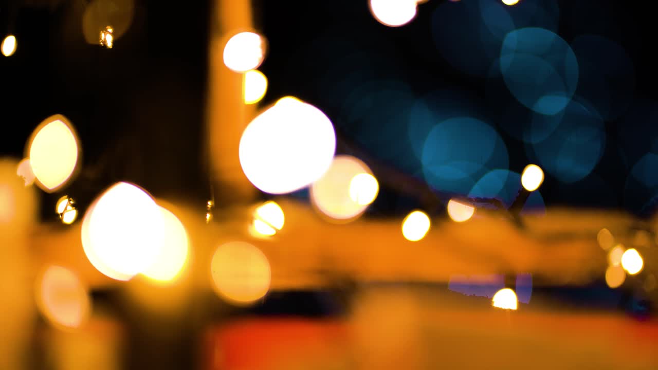 luces rojas amarillas cálidas con luces blancas azules parpadeando en el fondo