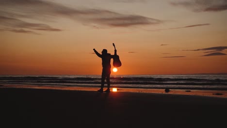 man running with guitar in back sand beach at sunset-33