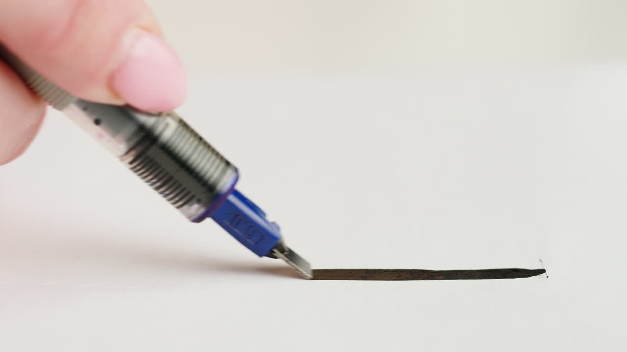 Nærbillede af Hånd der Tegner en Tyk Sort Streg med en Kalligrafipen