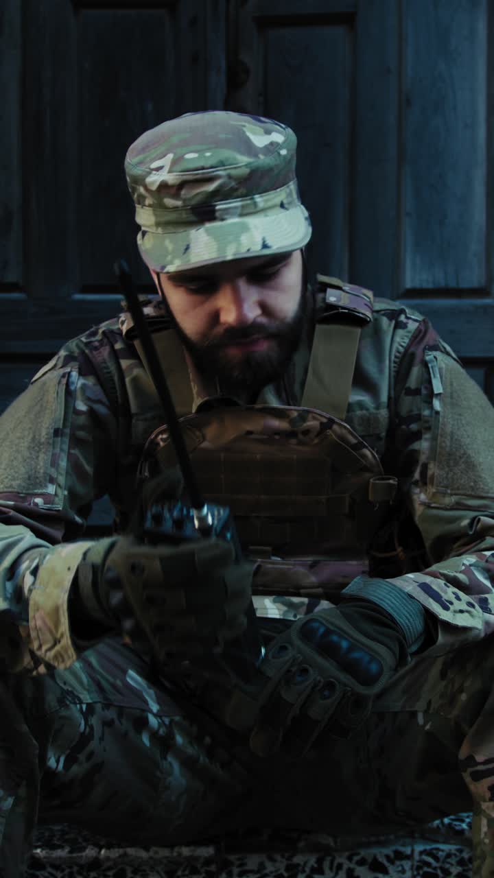 Soldier Sitting Near A Ruin Communicates With His Team