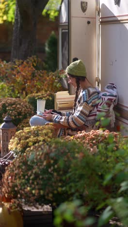 woman relaxing outdoors in an autumn garden with a tablet