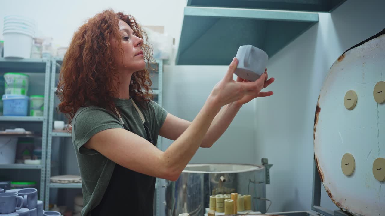 Woman checking ceramic mug in a pottery studio