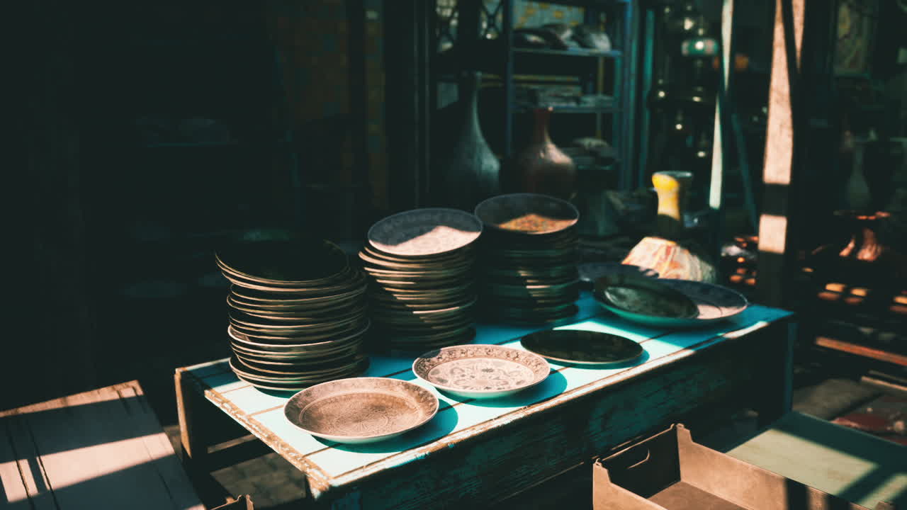 Stacked plates and bowls displayed on a wooden table in a market
