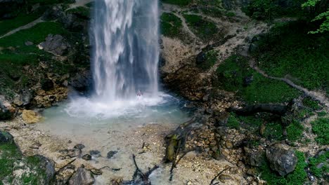 el hombre con barba está haciendo meditación de cascada bajo una gran cascada.