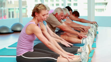 Exercise-class-stretching-and-touching-their-toes