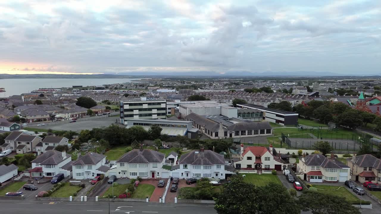 Holyhead island coastal town suburb aerial view panning across to harbour docks seafront skyline