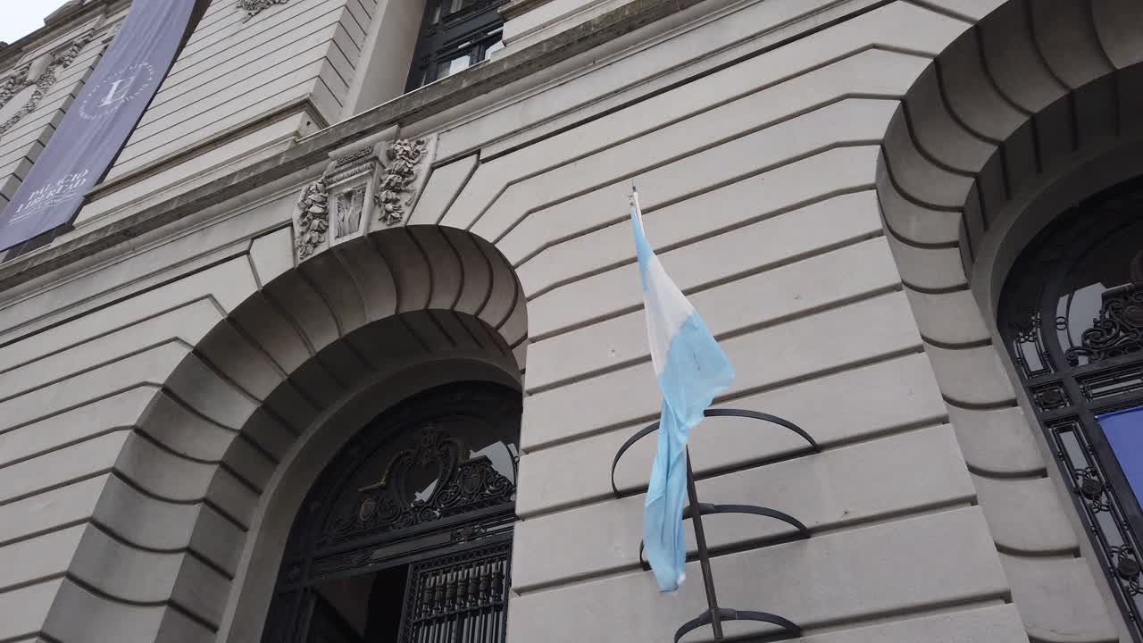 Low Angle view of Argentine flag waving in the wind with World Economic Forum banner background