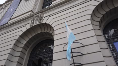 low angle view of argentine flag waving in the wind with world economic forum banner background