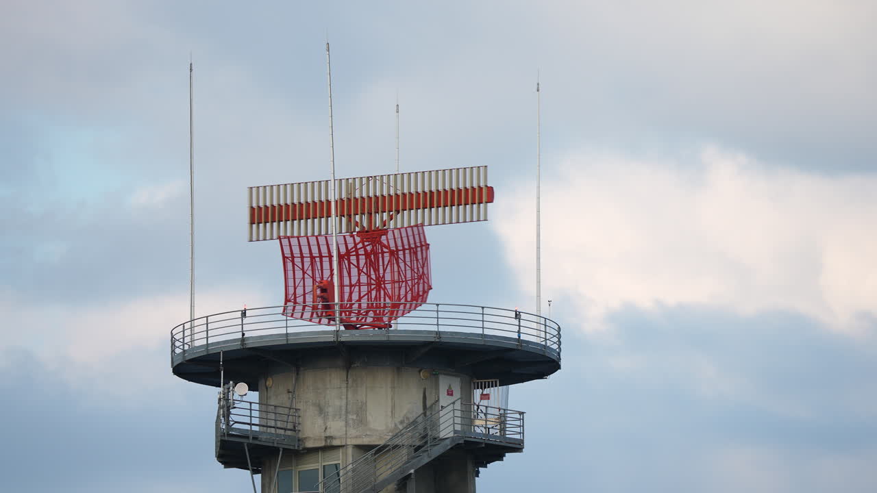 Detailed view of airport radar system with red rotating antenna mounted on tall tower