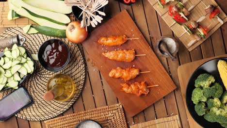 tracking shot over a wooden table with grilled meat and vegetables