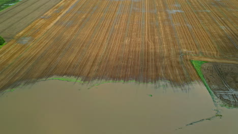 Vista-Aérea-De-Un-Campo-Agrícola-Parcialmente-Inundado-Que-Muestra-Patrones-De-Cultivos-Lineales-Claros-Sumergidos-En-Agua.