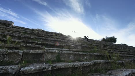 Schwarzer-Hund,-Der-Die-Treppe-Der-Antiken-Stadt-Hinabsteigt,-Und-Die-Frau,-Die-Oben-Auf-Der-Treppe-Steht