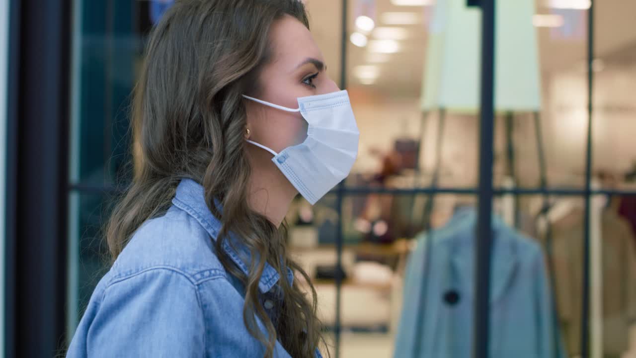 쇼핑몰에서 걸어다니는 보호 마스크를 입은 여성의 비디오