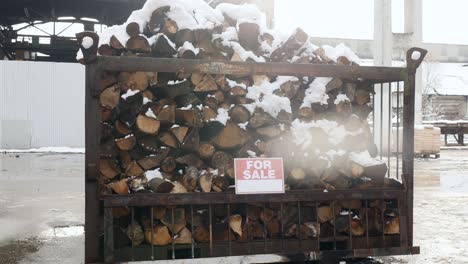 the stacked firewood under the snow "for sale