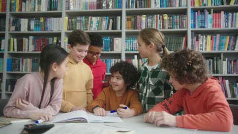 niños multinacionales rodean a un niño con el cabello pervertido en la biblioteca