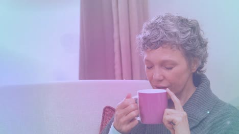 animación de puntos de luz sobre mujer caucásica sosteniendo taza y bebiendo