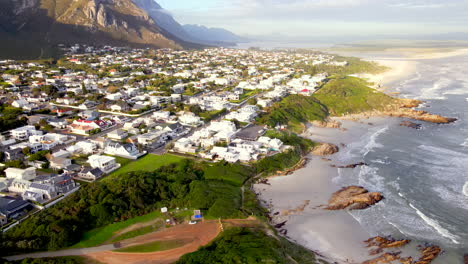 drone pullback view reveals stunning hermanus beaches near mountain, overstrand