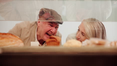 elderly couple browsing a bakery display