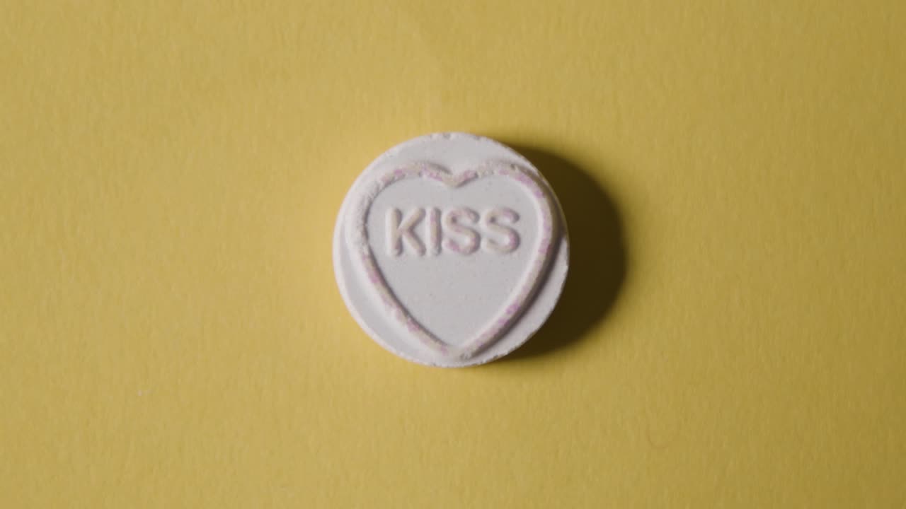 노란색 배경에 단어 키스가 있는 하트 캔디