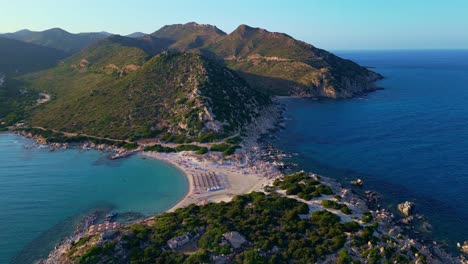 Volando-Sobre-La-Playa-De-Arena-De-Punta-Molentis-Y-Gente-De-Vacaciones-Debajo