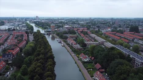 toma aérea de un barco en el río que atraviesa la ciudad en los países bajos