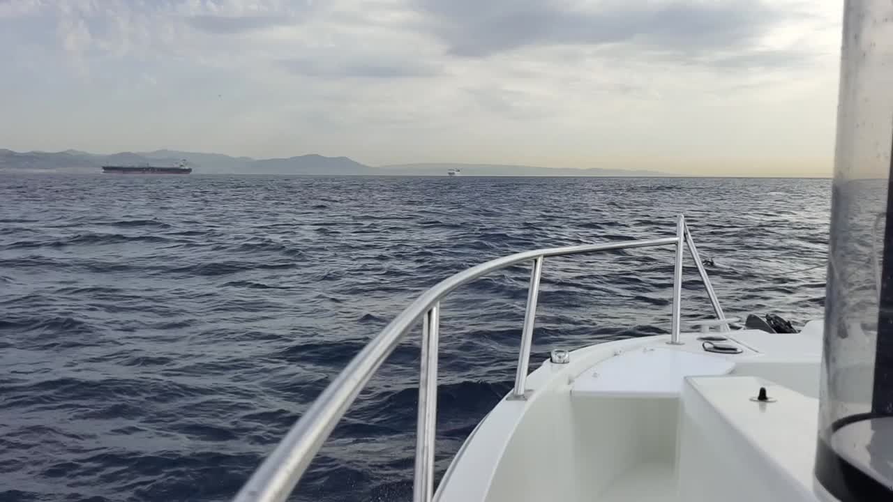 Ripresa al rallentatore di una barca che naviga nello Stretto di Gibilterra, mostrando il Marocco.