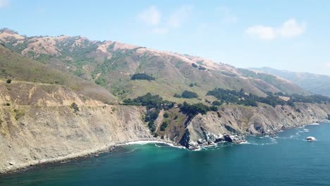 Impresionantes-Montañas-Sobre-El-Océano-Azul-Claro-En-Un-Día-Casi-Despejado,-California