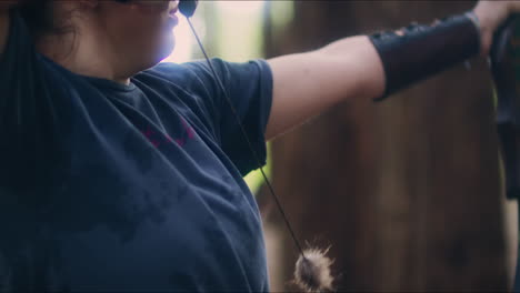 archery woman loads her bow and shoots medium shot