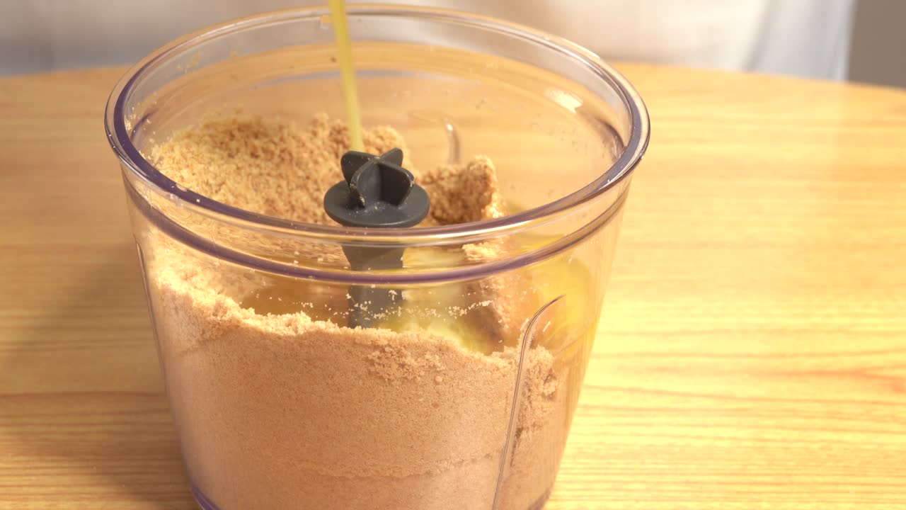 agregando mantequilla a las galletas trituradas para hacer una masa de pastel