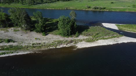 Flying-High:-Aerial-Perspective-of-a-Lush-Green-River-in-Summer,-Canada